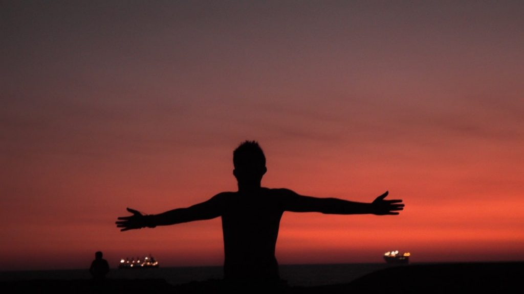 silhouette of man spreading both arms