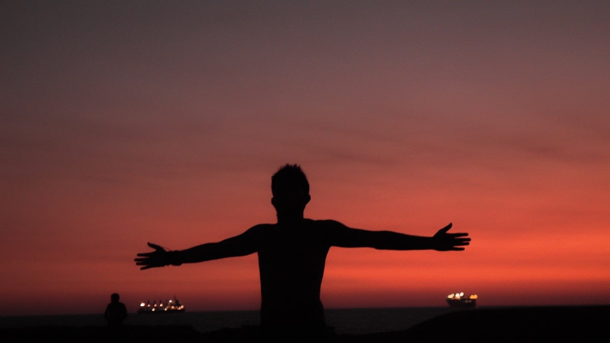 silhouette of man spreading both arms
